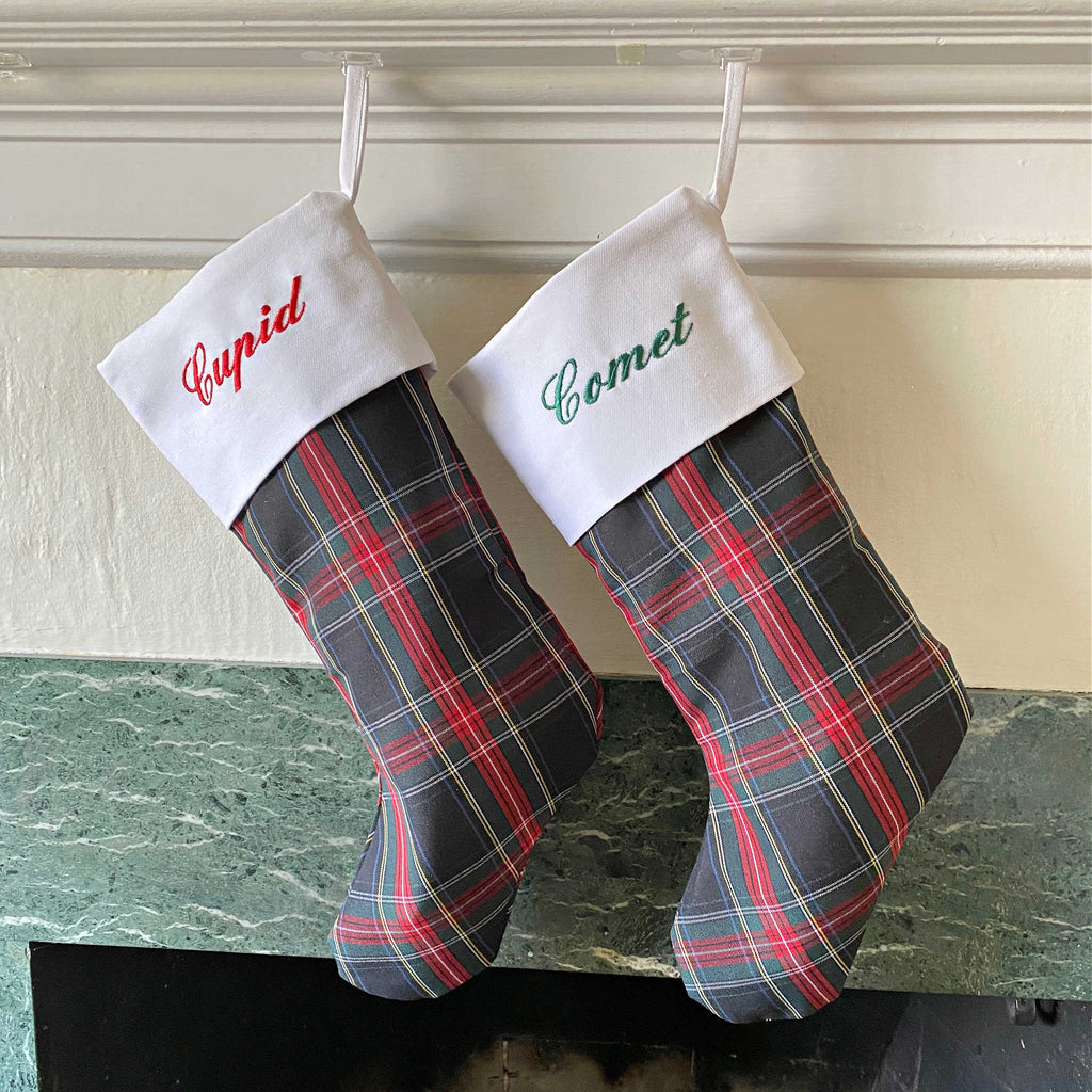 School Plaid holiday stockings hanging from a living room mantle