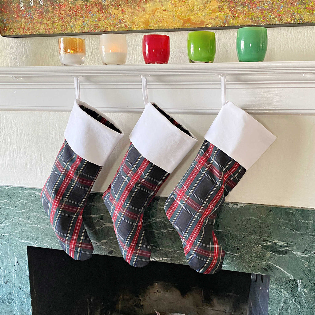 School Plaid holiday stockings hanging from a living room mantle