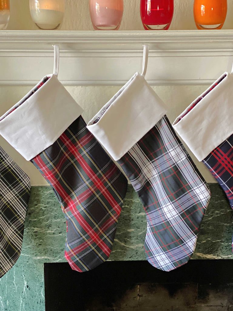 School Plaid holiday stockings hanging from a living room mantle