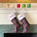 School Plaid holiday stockings hanging from a living room mantle